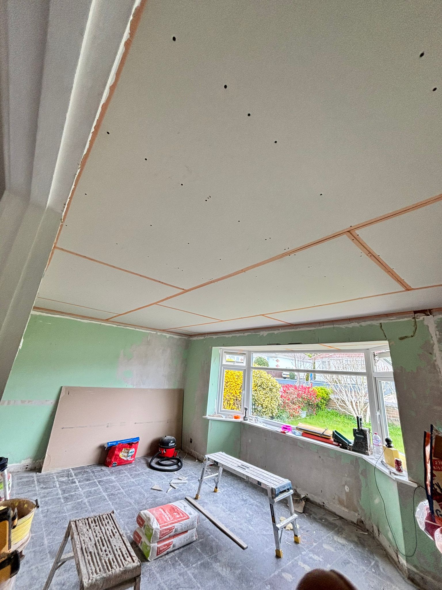 Exposed plasterboard framework with wooden ceiling struts before skimming